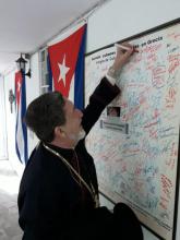 Su Eminencia Arzobispo Atenágoras firma en Atenas mural contra el bloqueo a Cuba.