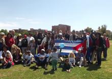 Cubanos residentes en Italia y colectivo de la Misión cubana sostienen la bandera nacional en clausura encuentro deportivo.